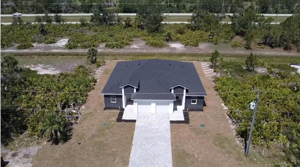 An aerial view of a new duplex with a dark roof and a paved driveway — 10380 PORT EVERGLADES STREET, PORT CHARLOTTE, FL