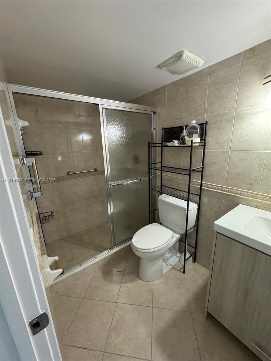 A bathroom features a walk-in shower with glass doors, a toilet, and a vanity — 10296 NW 9th St Cir # 202, Miami FL 33172, MIAMI, FL