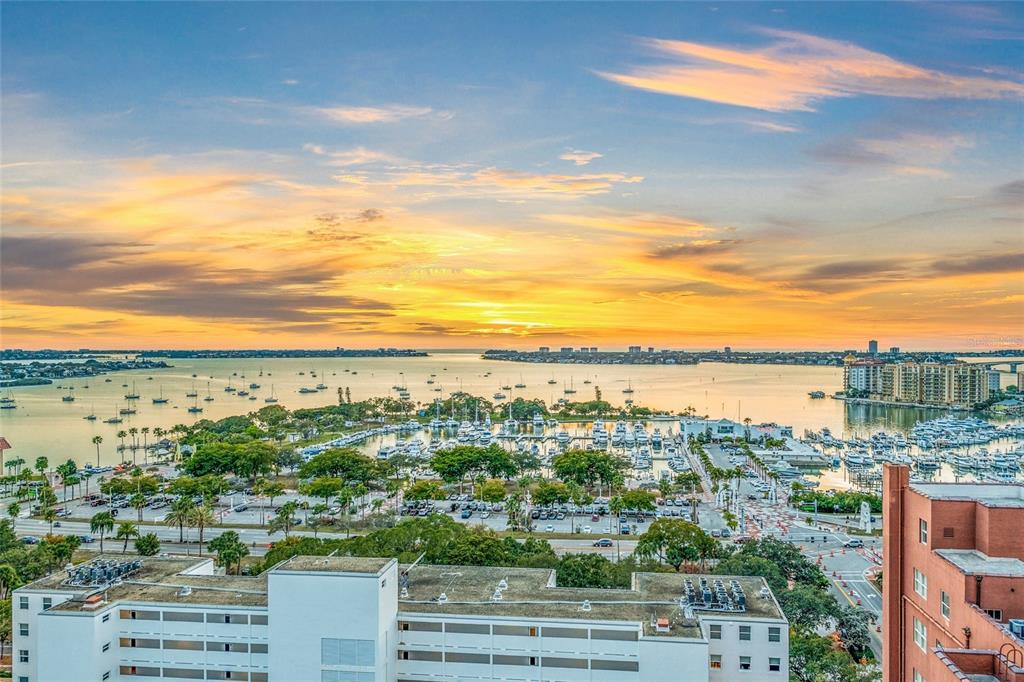 An elevated view of a marina and bay at sunset with nearby buildings and parking — 1330 MAIN STREET UNIT PH 9 & 10, SARASOTA, FL