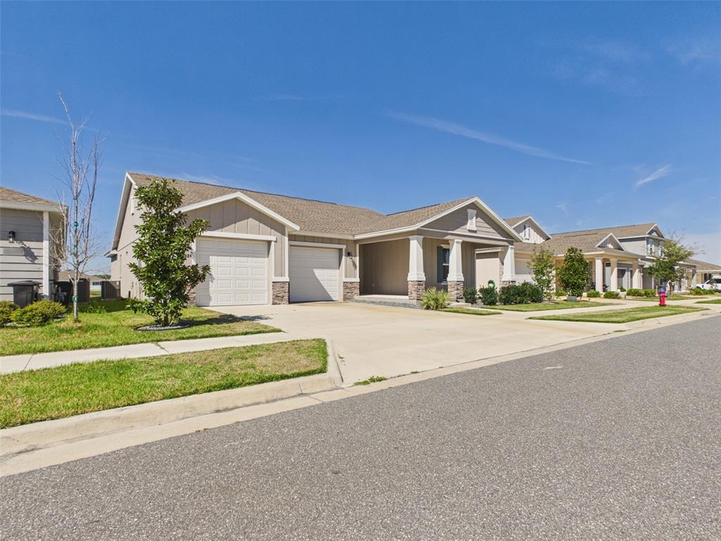 A suburban house with a two-car garage and a covered front porch under a blue sky — 6224 SW 74TH TERRACE ROAD, OCALA, FL
