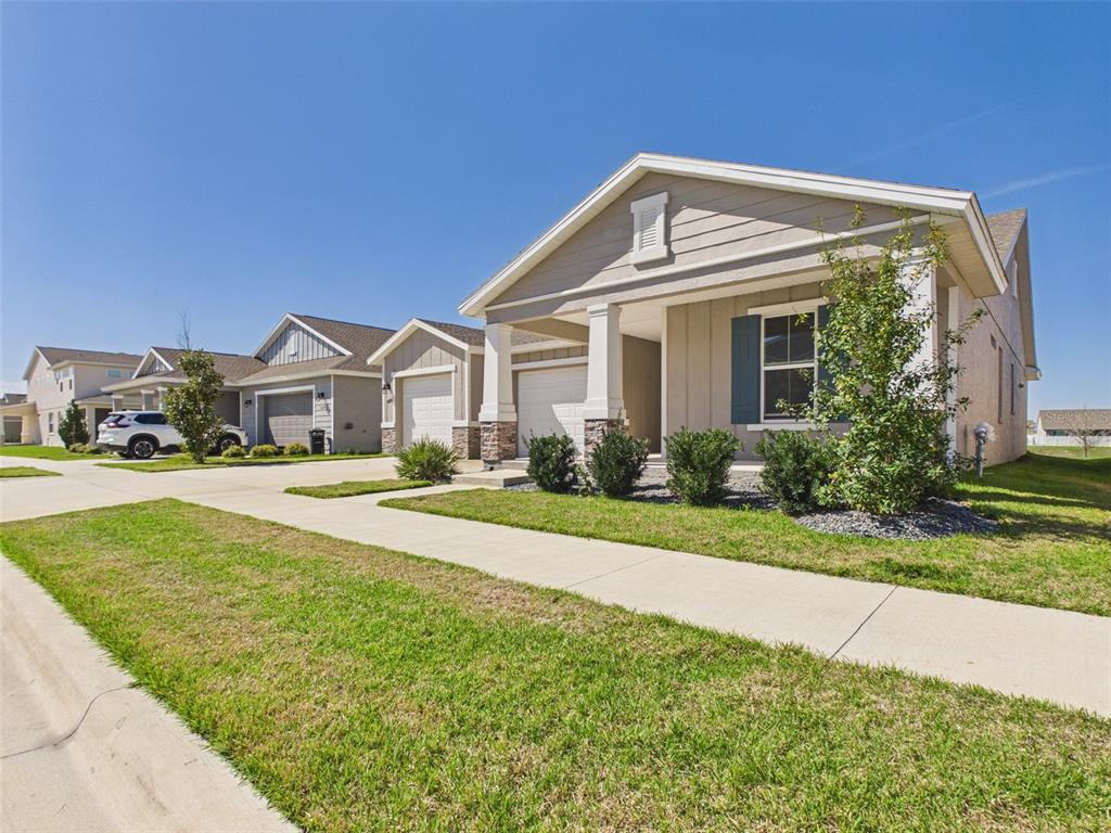 A row of single-story suburban houses with driveways and manicured lawns under a clear sky — 6224 SW 74TH TERRACE ROAD, OCALA, FL