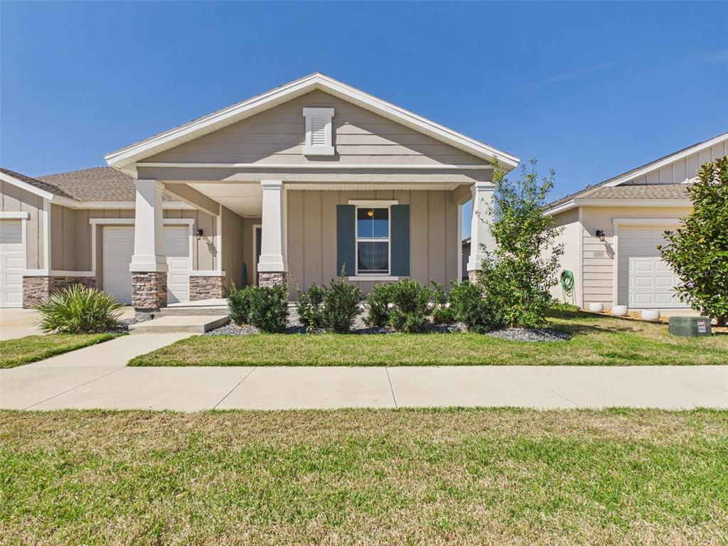 A single-story house with beige siding, a covered front porch, and a stone-accented entryway — 6224 SW 74TH TERRACE ROAD, OCALA, FL