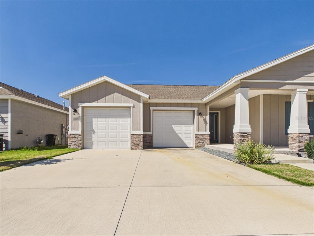 A single-story house features a two-car garage, stone accents, and a covered entryway — 6224 SW 74TH TERRACE ROAD, OCALA, FL