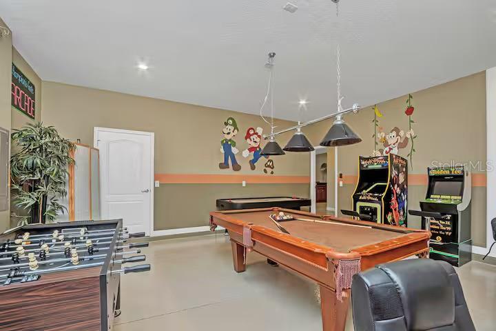 A game room features a pool table, foosball table, arcade cabinets, and Mario-themed wall decals — 1454 BELLE TERRE ROAD, DAVENPORT, FL