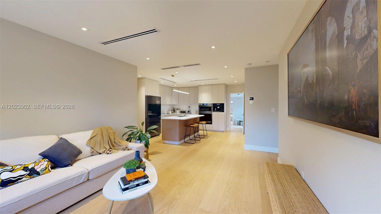 An open-concept living room and kitchen feature light wood flooring and modern cabinetry — 1277 SW 19th St, Miami FL 33145, MIAMI, FL