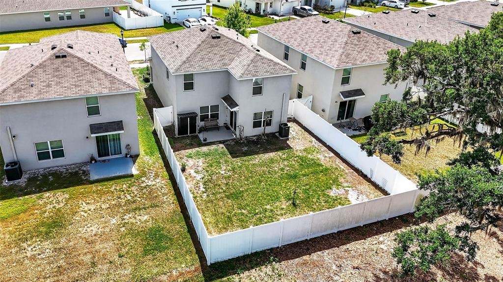 A two-story suburban house features a light gray stucco exterior, a garage, and a driveway — 13765 WHISKEY DAISY DRIVE, DADE CITY, FL