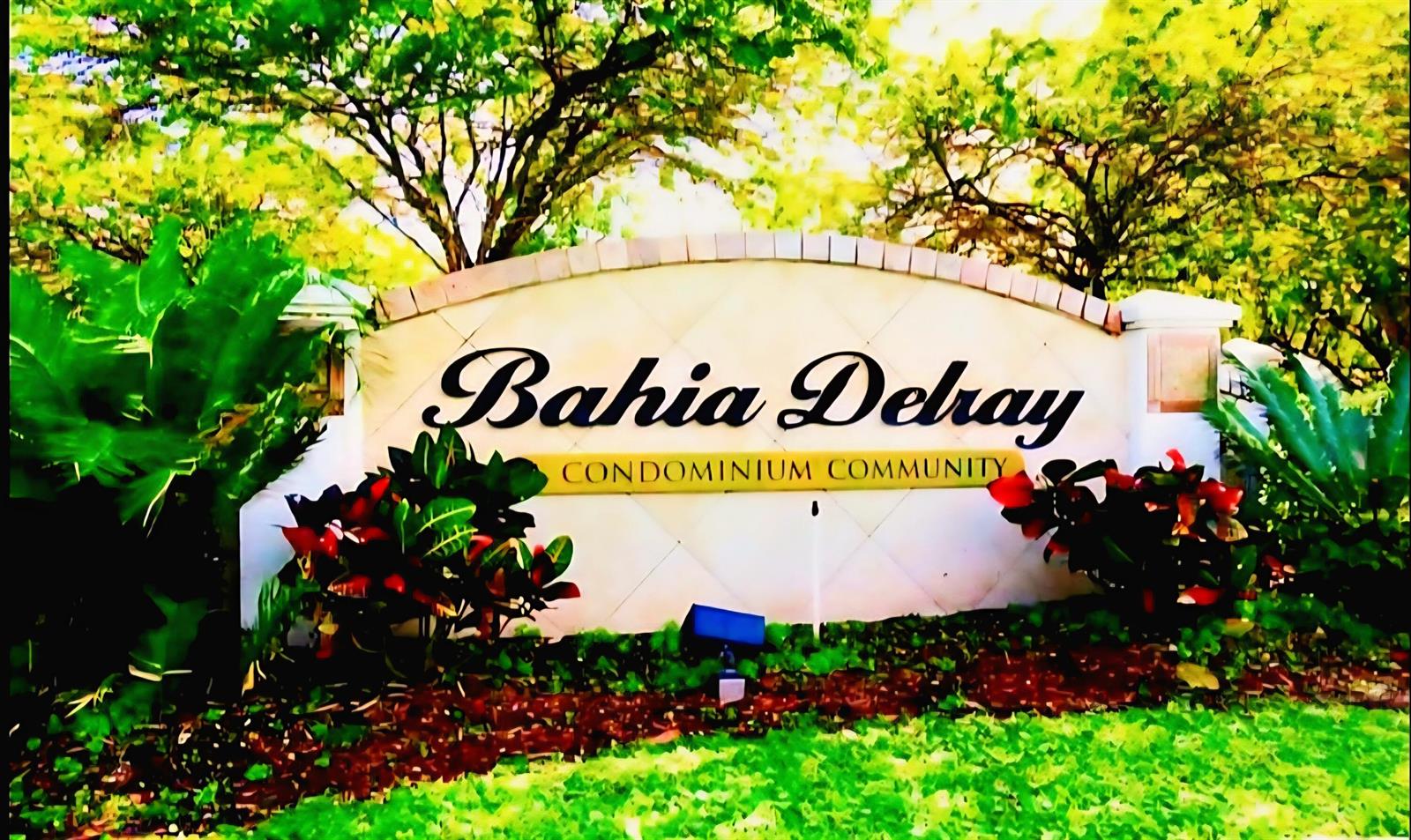 A stone sign for the Bahia Delray condominium community stands surrounded by trees and plants — 1020 Crystal Way # F, Delray Beach FL 33444, DELRAY BEACH, FL