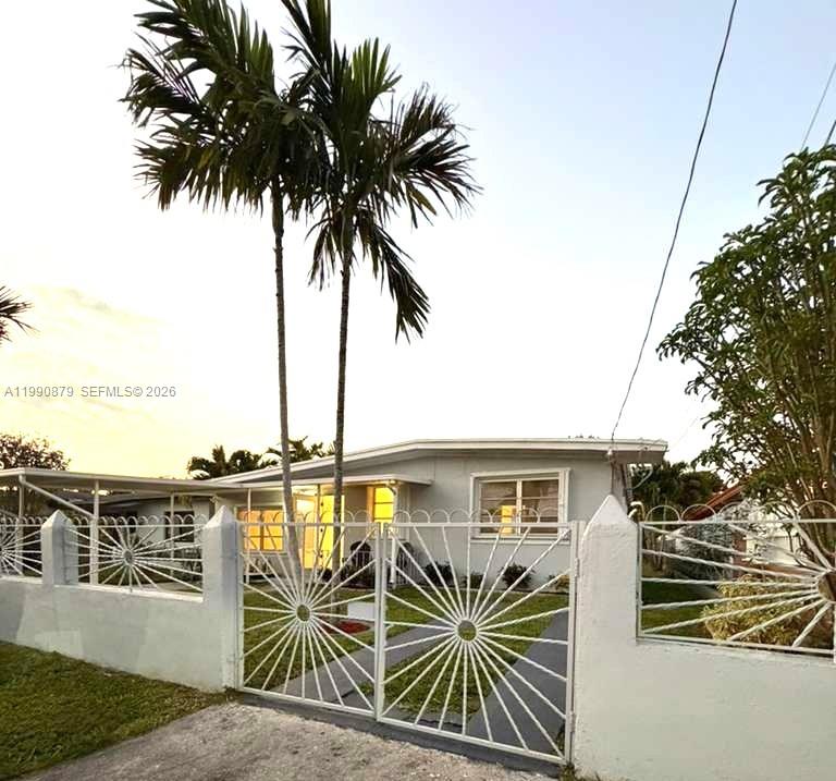 A single-story house with a white fence and gate stands behind two tall palm trees — 6339 SW 32nd St, Miami FL 33155, MIAMI, FL