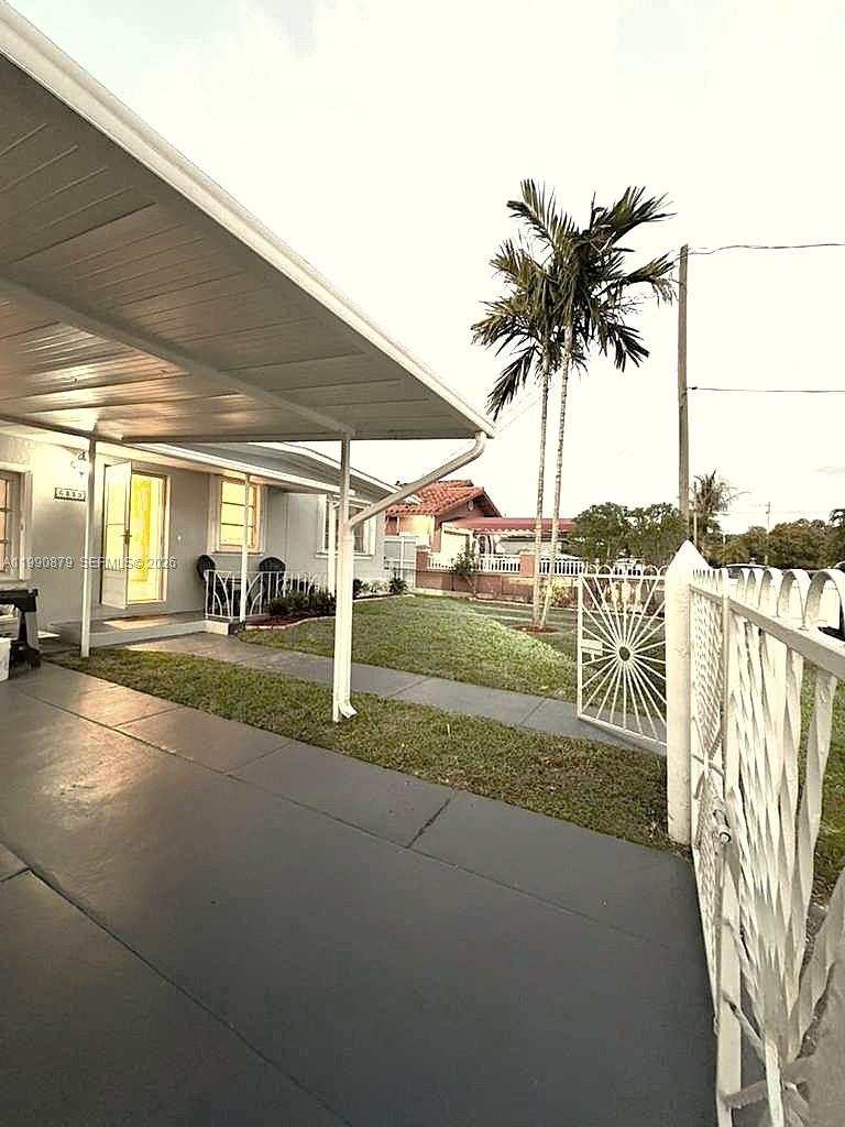 A gray-painted patio sits under a white metal carport next to a house exterior — 6339 SW 32nd St, Miami FL 33155, MIAMI, FL