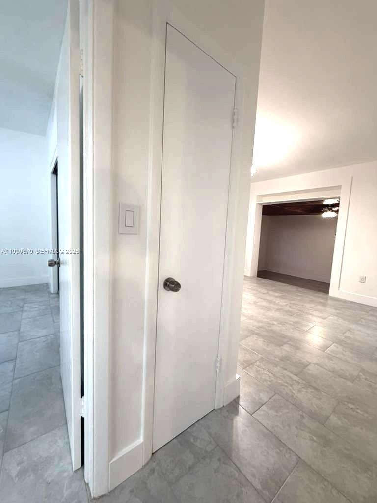 A white door with a round knob stands in a room with light-colored tile flooring — 6339 SW 32nd St, Miami FL 33155, MIAMI, FL