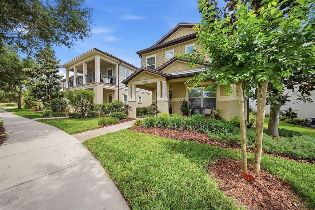 A two-story house with a covered front porch and a sidewalk leading to the entrance — 5920 VILLAGE CENTER DRIVE, LITHIA, FL