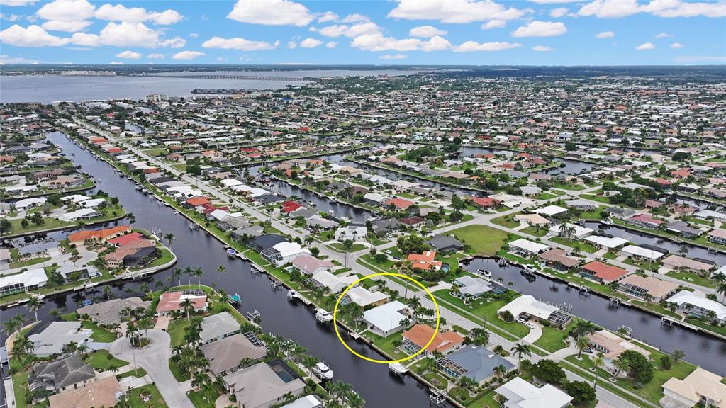 An aerial view of a waterfront residential neighborhood with a yellow circle highlighting a house — 931 BAL HARBOR BOULEVARD, PUNTA GORDA, FL
