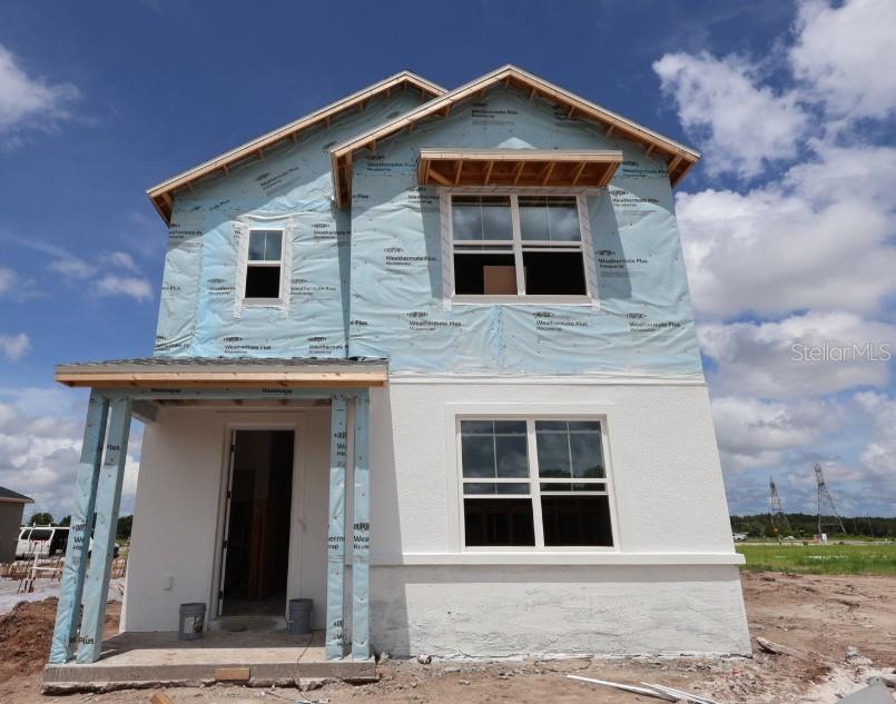 A two-story house exterior features light gray siding, vertical gray accents, and a stone base — 2851 CRIMSON CAP STREET, ODESSA, FL