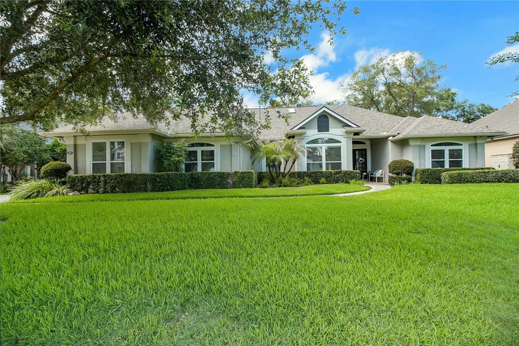 A single-story house with a beige exterior, a large front lawn, and mature trees — 365 WOLDUNN CIRCLE, LAKE MARY, FL