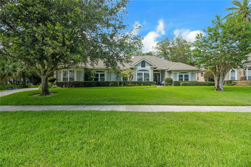 A single-story house with a light-colored exterior, a gabled roof, and a large front lawn — 365 WOLDUNN CIRCLE, LAKE MARY, FL