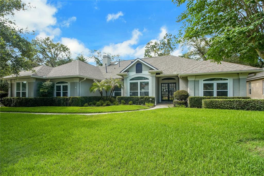 A single-story house with a gray stucco exterior, a shingled roof, and a manicured lawn — 365 WOLDUNN CIRCLE, LAKE MARY, FL