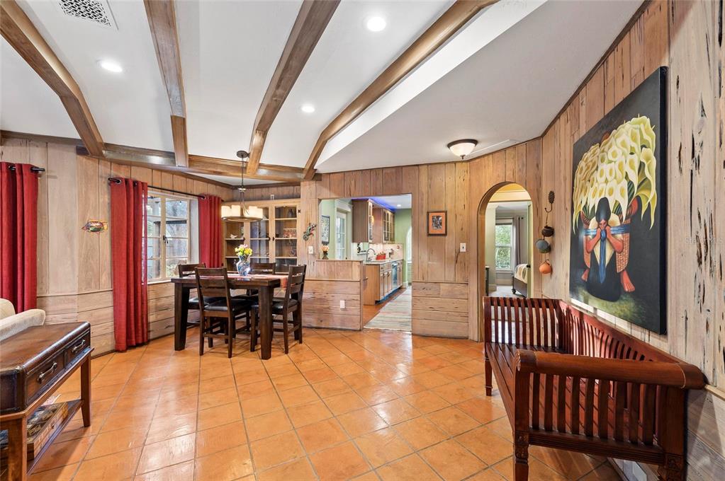 A dining area with wood-paneled walls, tile flooring, and exposed ceiling beams — 941 VIRGINIA DRIVE, SARASOTA, FL