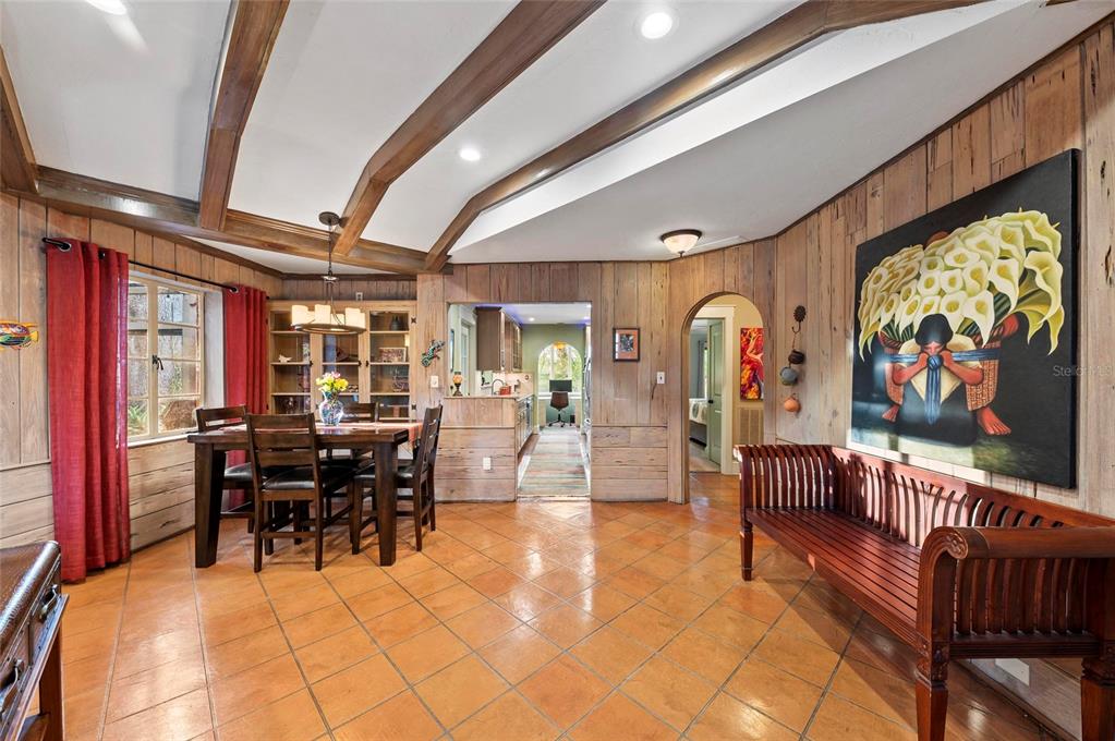 A dining room features wood-paneled walls, a vaulted ceiling with beams, and terracotta tile flooring — 941 VIRGINIA DRIVE, SARASOTA, FL