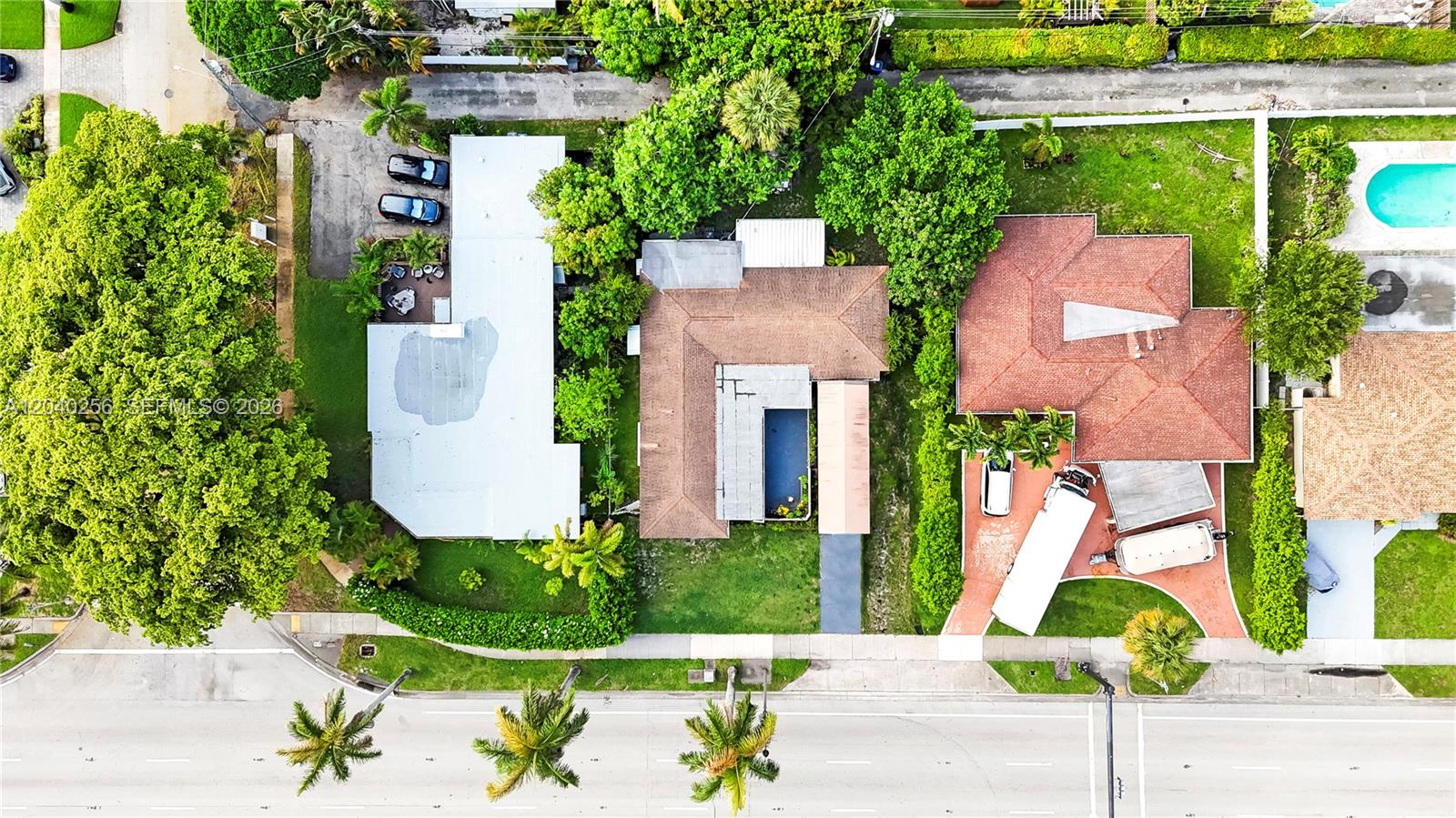 An aerial view shows three residential properties with pools, driveways, and lush landscaping — 3145 Hollywood Blvd, Hollywood FL 33021, HOLLYWOOD, FL