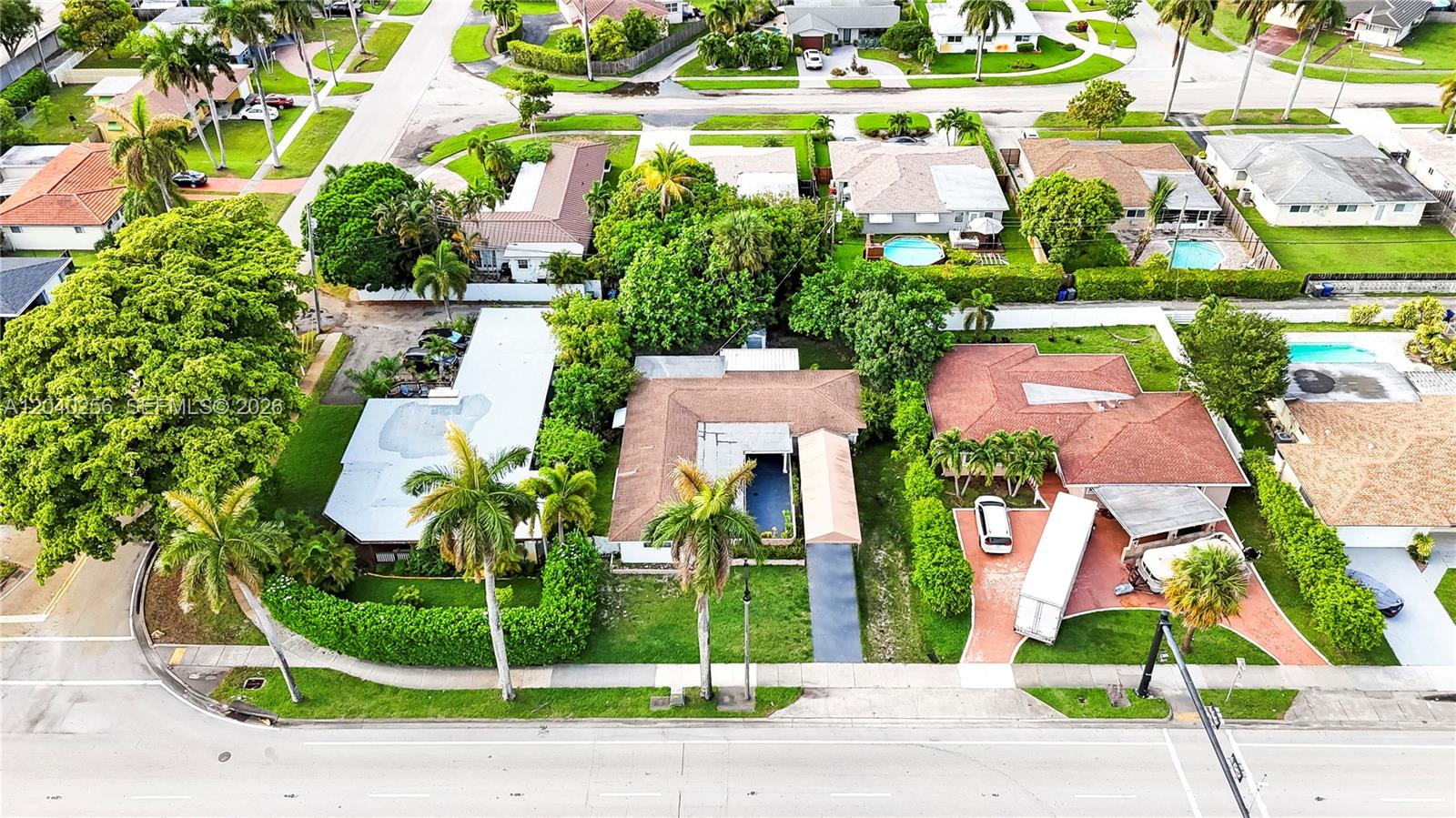 An aerial view shows several residential houses with swimming pools and palm trees in a neighborhood — 3145 Hollywood Blvd, Hollywood FL 33021, HOLLYWOOD, FL
