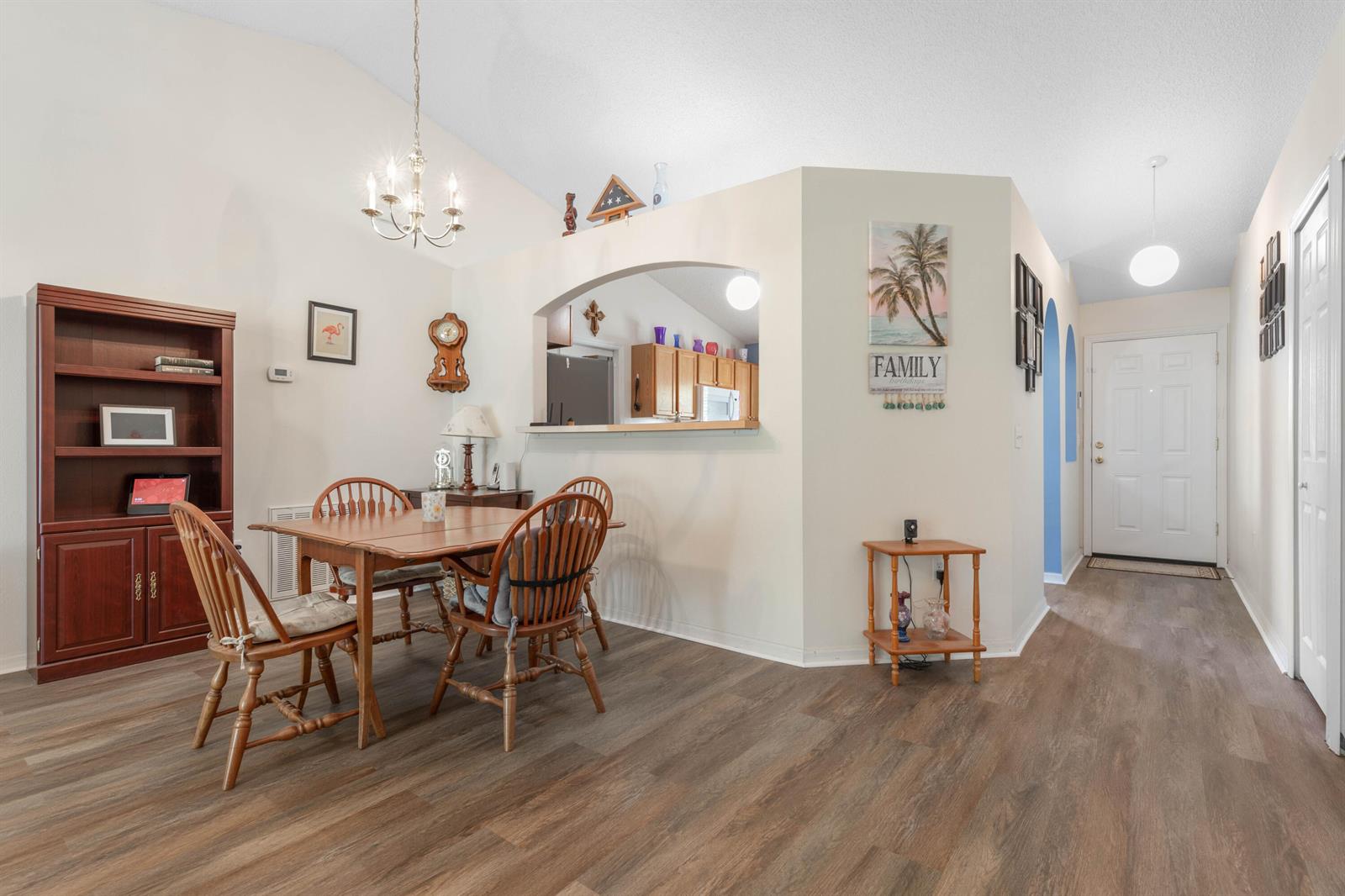 A dining area with wood flooring, a wooden table, and a pass-through to the kitchen — 38 Lloyd Trail, Palm Coast FL 32164, PALM COAST, FL