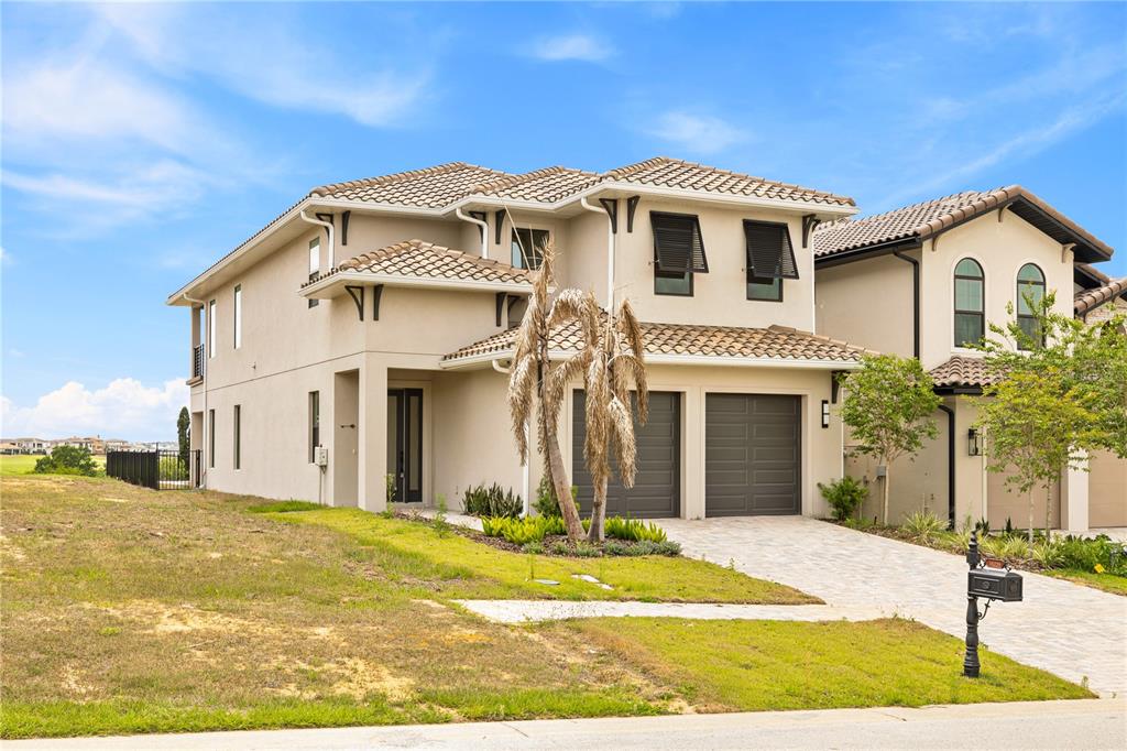 A two-story beige stucco house with a tiled roof and a two-car garage — 16229 RAVENNA COURT, BELLA COLLINA, FL