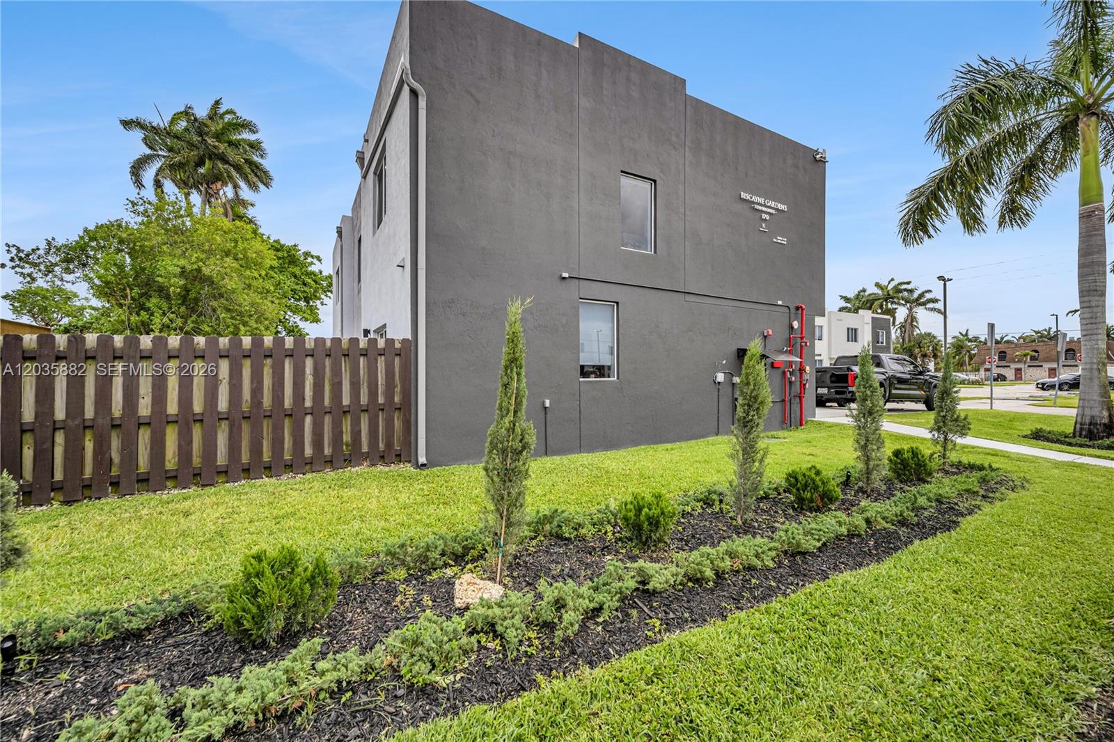 A kitchen island with a sink overlooks a living area with a sofa and patio — 171 NW 158th St # 1, Miami FL 33169, MIAMI, FL
