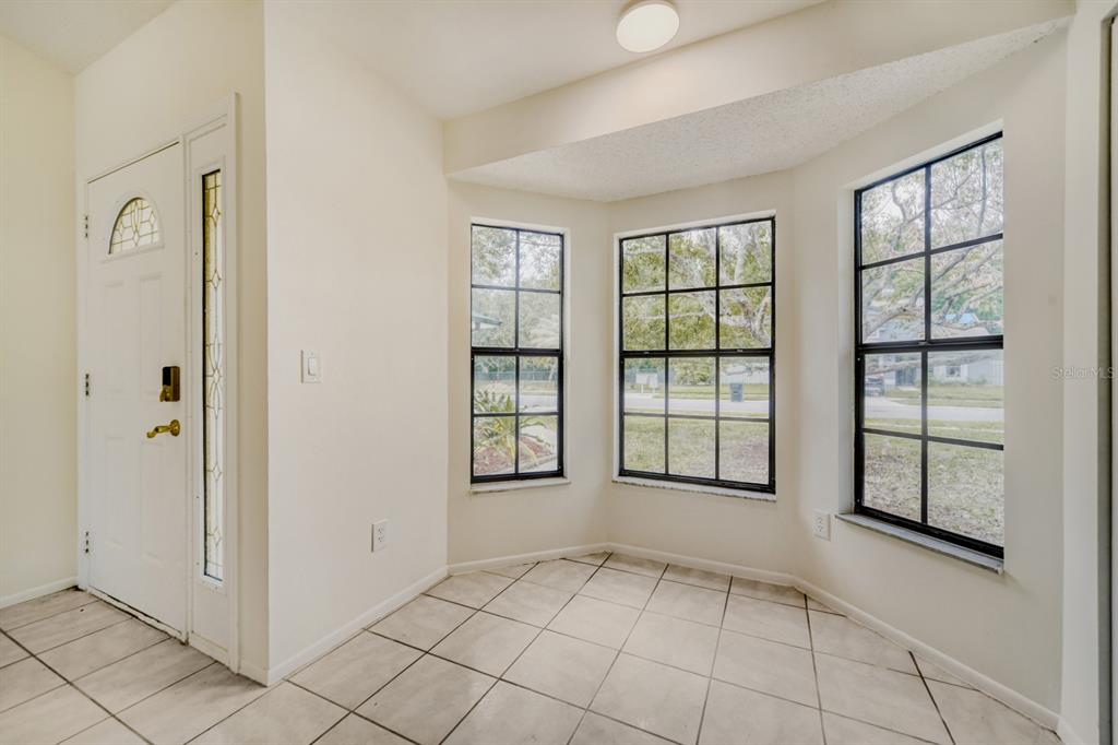 An entryway with light tile flooring, a white front door, and a three-paneled bay window — 2627 TALON COURT, ORLANDO, FL