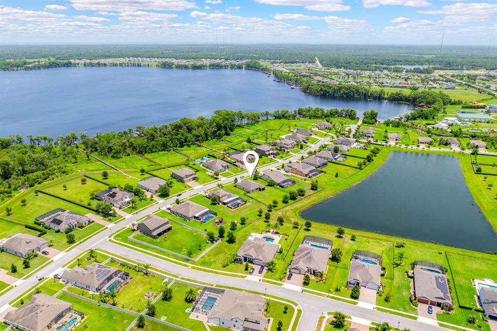 An aerial view shows a suburban neighborhood with houses, a large lake, and a pond — 17590 SAILFIN DRIVE, ORLANDO, FL
