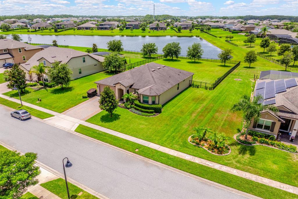 An aerial view shows a suburban house with a large lawn and a nearby pond — 17590 SAILFIN DRIVE, ORLANDO, FL