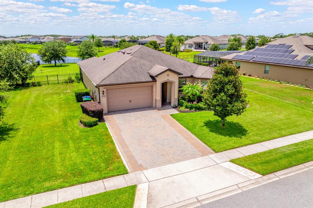 An aerial view of a single-story suburban house with a paved driveway and green lawn — 17590 SAILFIN DRIVE, ORLANDO, FL