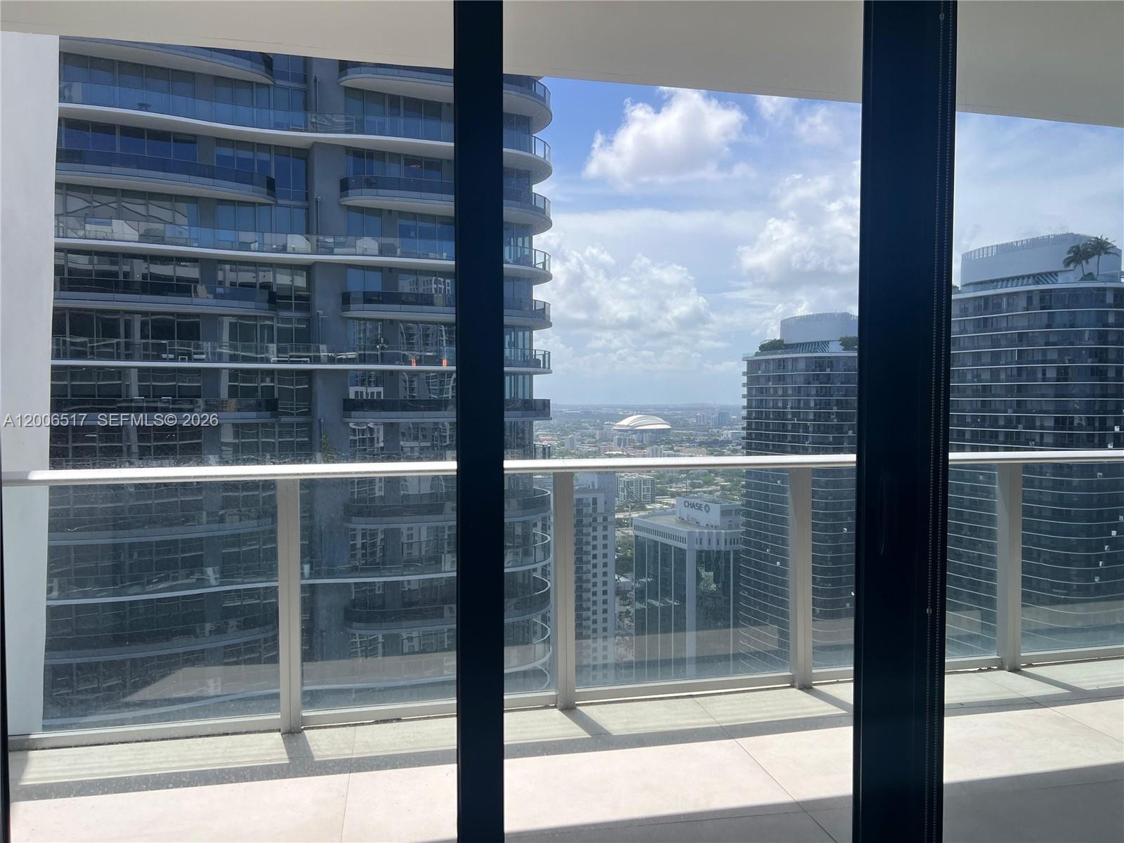 A balcony with a glass railing overlooks a city skyline with several high-rise buildings — 1010 Brickell Ave # 4609, Miami FL 33131, MIAMI, FL