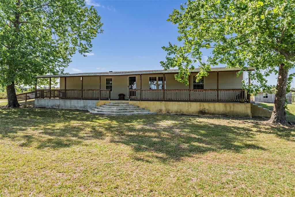 An aerial view shows a house and outbuildings on a large, fenced-in rural property — 6606 GATOR RANCH STREET, PLANT CITY, FL
