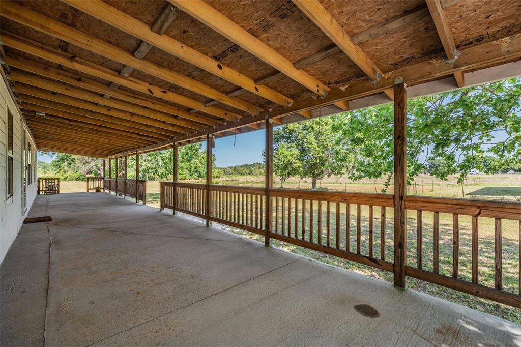 A single-story house with a long front porch and concrete steps sits on a lawn — 6606 GATOR RANCH STREET, PLANT CITY, FL