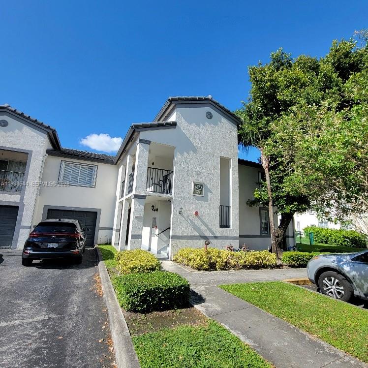 A two-story residential building with a black car parked in front of the garage — 4370 NW 107th Ave # 107, Doral FL 33178, DORAL, FL
