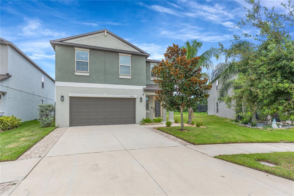 A two-story house with a green facade, a two-car garage, and a concrete driveway — 5522 APPLETON SHORE DRIVE, APOLLO BEACH, FL