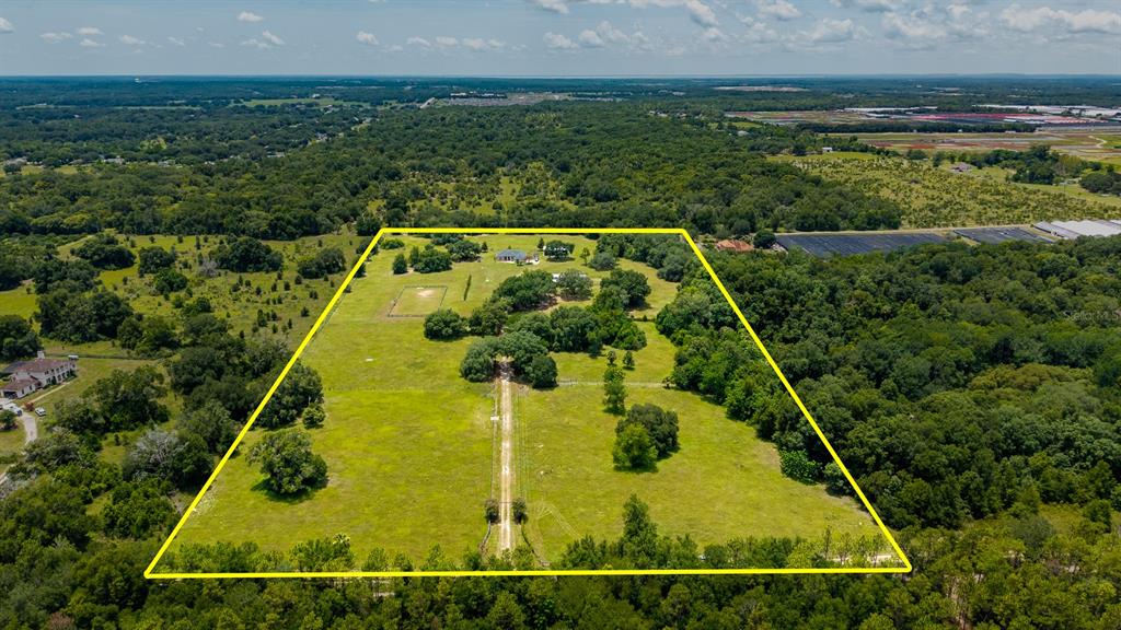 An aerial view shows a large, fenced rural property with a house and driveway — 21341 HORSE RANCH ROAD, MOUNT DORA, FL