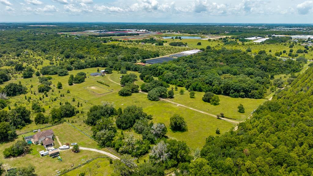 An aerial view shows a house with a pool on a large, grassy rural property — 21341 HORSE RANCH ROAD, MOUNT DORA, FL