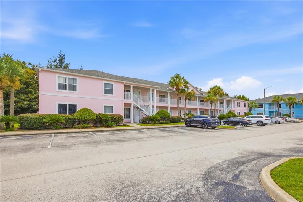 A two-story pink apartment building with an outdoor staircase and a paved parking lot — 3157 SUN LAKE COURT UNIT A, KISSIMMEE, FL