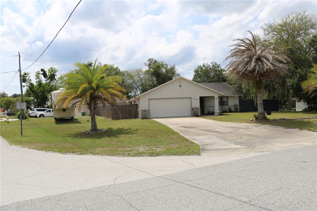 A single-story house with a two-car garage, a concrete driveway, and two palm trees — 2392 BRIMHALL COURT, DELTONA, FL