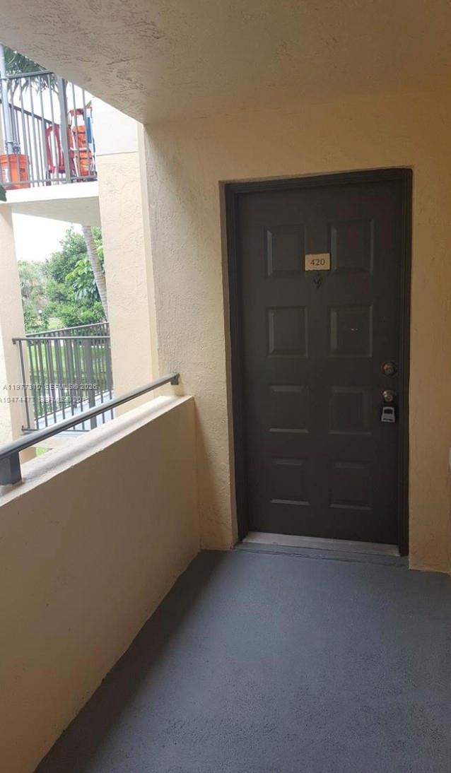 A dark brown apartment door labeled 420 is located on an outdoor balcony — 9999 Summerbreeze Dr # 420, Sunrise FL 33322, SUNRISE, FL