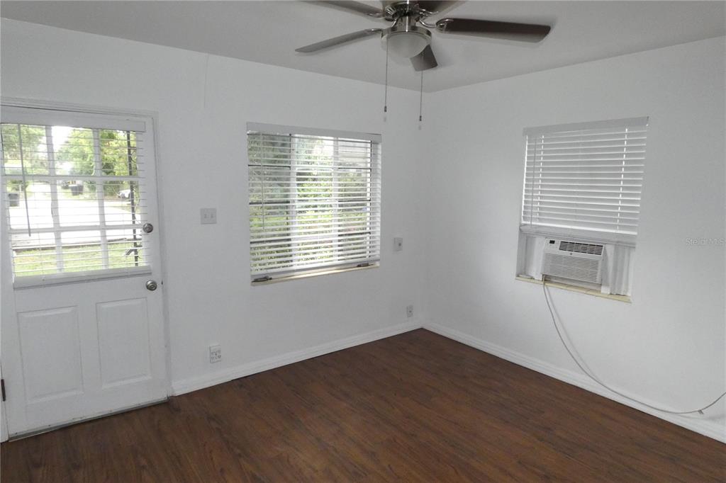 A room with white walls, wood-look flooring, a ceiling fan, and a window air conditioner — 2567 15TH AVENUE N UNIT 2, ST PETERSBURG, FL