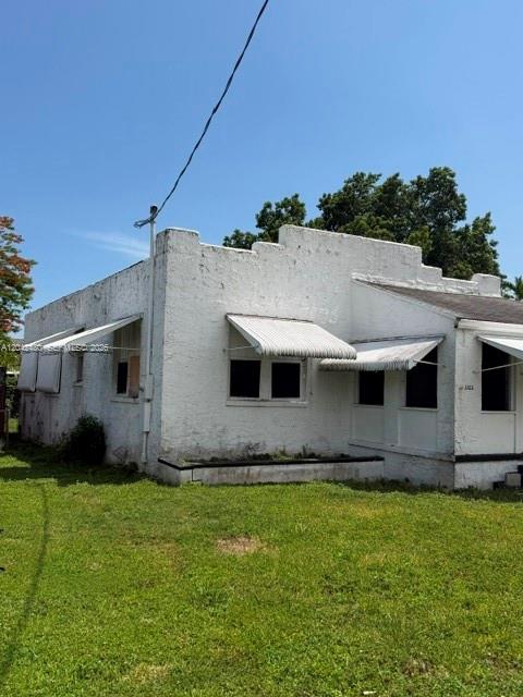 A white, single-story stucco building features a stepped parapet roofline and several metal window awnings — 3322 SW 9th St, Miami FL 33135, MIAMI, FL