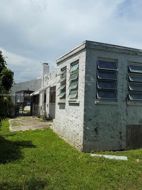 The exterior of a light-colored, single-story building features multiple louvered windows and a chimney — 3322 SW 9th St, Miami FL 33135, MIAMI, FL