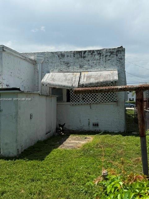 The exterior of a weathered white building features a metal awning over a window — 3322 SW 9th St, Miami FL 33135, MIAMI, FL