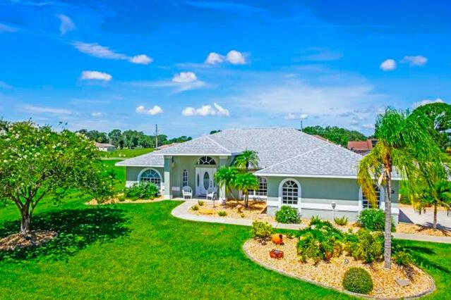 A light green single-story house with a gray shingled roof sits on a grassy lawn — 424 Holly Drive, Sebring FL 33876, SEBRING, FL