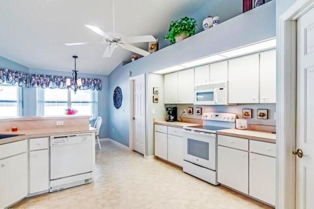 A kitchen with white cabinets, white appliances, and a ceiling fan over a dining area — 424 Holly Drive, Sebring FL 33876, SEBRING, FL