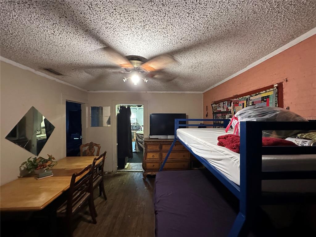 A multi-purpose room features a dining table, a bunk bed, and a wooden dresser — 1105 NE 1ST STREET, MULBERRY, FL