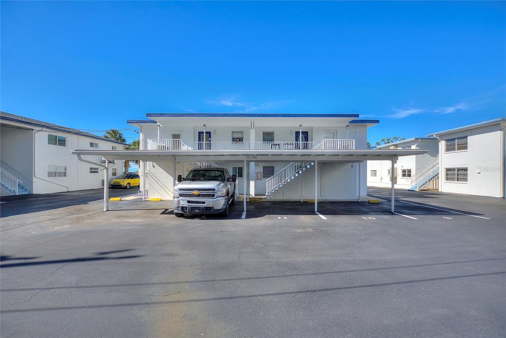 A two-story apartment building features a covered parking area with a parked pickup truck — 4300 37TH STREET S UNIT 4, ST PETERSBURG, FL