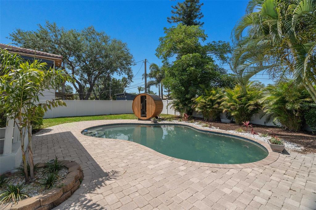A backyard features a kidney-shaped swimming pool, a wooden barrel sauna, and paver patio flooring — 1715 DELAWARE AVENUE NE, ST PETERSBURG, FL